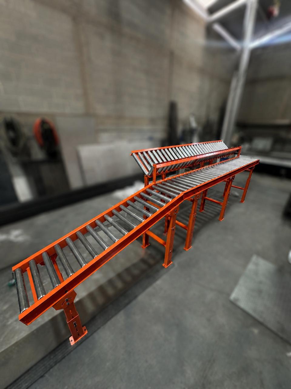 Detalle del transportador de rodillos naranja fabricado en taller INDUBA